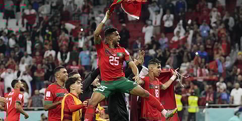 Morocco's Yahia Attiyat Allah celebrates with teammates after the World Cup quarterfinal soccer match against Portugal.(Photo | AP)