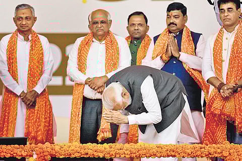 Prime Minister Narendra Modi greets supporters during the swearing-in ceremony of Gujarat Chief Minister Bhupendra Patel (second-L) in Gandhinagar. (Photo | PTI)