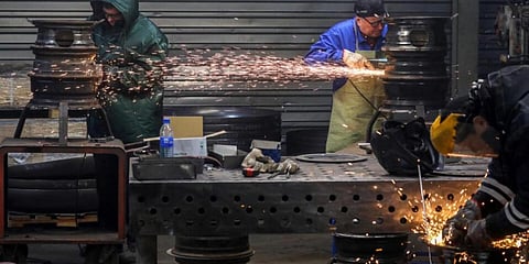 Workers of Lithuanian metal processing company 'Kalvis' weld old wheel rims to create heating stoves for Ukrainian civilians and soldiers .(Photo | AFP)