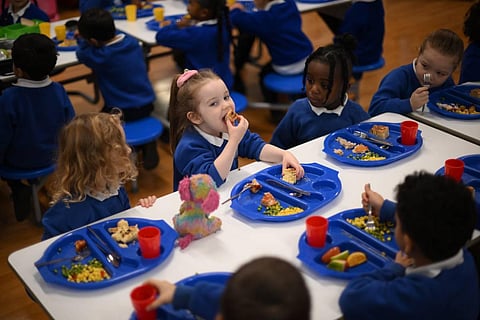 Children eat during lunch-break at St Mary's RC Primary School, in Battersea, south London, on November 29, 2022. (Photo | AFP)