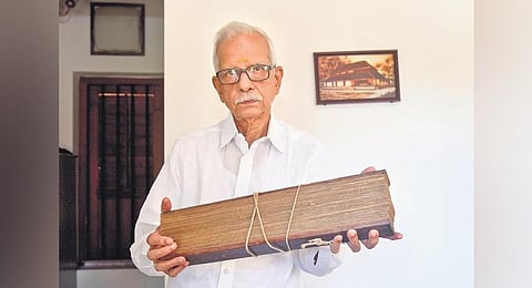 Krishnabalan Paliath, manager of Paliam Eswara Seva Trust, with a single bundle of the palm leaf manuscript | A Sanesh