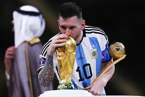 Argentina's Lionel Messi kisses the World Cup trophy as he holds the Golden Ball award for best player of the tournament. (Photo | AP)