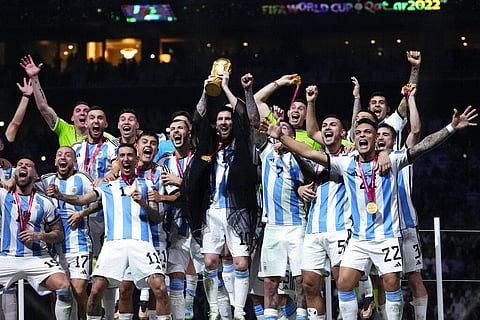 Argentina's Lionel Messi holds up the trophy after winning the World Cup final soccer match between Argentina and France at the Lusail Stadium in Lusail, Qatar | AP