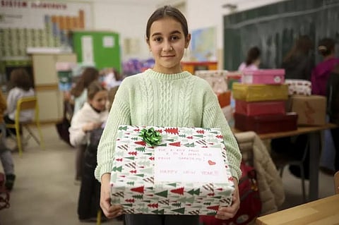Merjem, 10, poses for a photo with one of the presents prepared for Ukrainian children at Safvet Beg Basagic elementary school in Sarajevo, Bosnia. (Photo | AP)