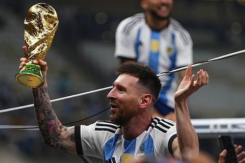 Argentina's Lionel Messi celebrates with the trophy after winning the World Cup final soccer match between Argentina and France at the Lusail Stadium in Lusail, Qatar | AP