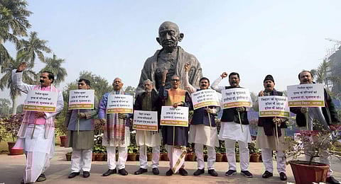 Bihar BJP members stage a protest near the Gandhi Statue demanding compensation for the victims of Saran hooch tragedy, during Winter Session of Parliament, in New Delhi. (Photo | PTI)