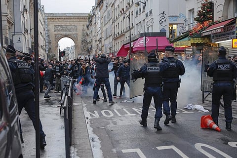 Members of Kurdish community clashe with police officer at the crime scene where a shooting took place in Paris, Friday, Dec. 23, 2022. (Photo | AP)