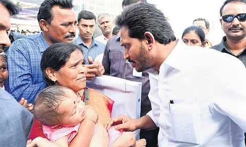 Chief Minister YS Jagan Mohan Reddy promises all help to a woman who met him seeking medical aid for her infant son, in Kadapa district on Saturday I Express