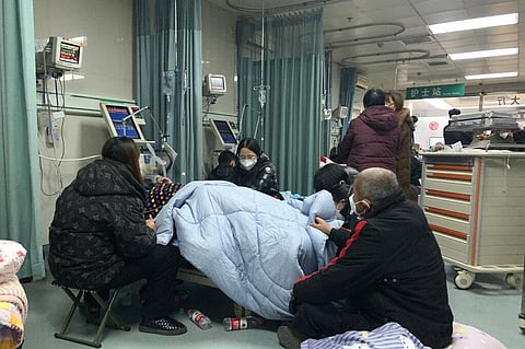 Relatives gather near the bed of a sickened patient at the emergency department of the Langfang No. 4 People's Hospital in Bazhou city in northern China's Hebei province, Dec. 22, 2022. (Photo | AP)