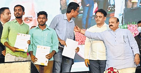 Chief Minister Basavaraj Bommai hands over offer letters to aspirants in Bengaluru on Sunday. Minister Dr CN Ashwath Narayan looks on | Nagaraja Gadekal