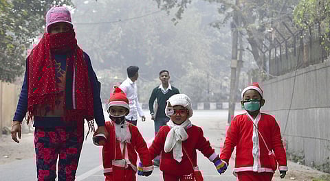 Children dressed as Santa Claus on their way to attend school amid fog during a cold winter day in New Delhi. (Photo | Shekhar Yadav, EPS)