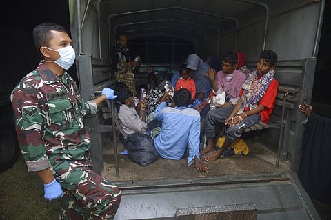 Ethnic Rohingya people sit at the back of a military truck upon arrival at a temporary shelter after their boat landed in Pidie, Aceh province, Indonesia. (Photo | AP)