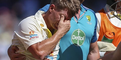 Australia's David Warner, left, reacts as he is assisted from the field as he retires injured after reaching 200 runs during the second cricket test against South Africa.(Photo | AP)
