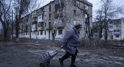 A local woman walks to the distribution point of humanitarian aid in front of housing which was damaged by Russian shelling in Kupiansk, Kharkiv region, Ukraine. (Photo | AP)