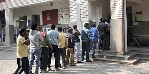 Voters wait in a queue to cast their votes for the Municipal Corporation of Delhi (MCD) elections, at a polling station. (Photo | PTI)
