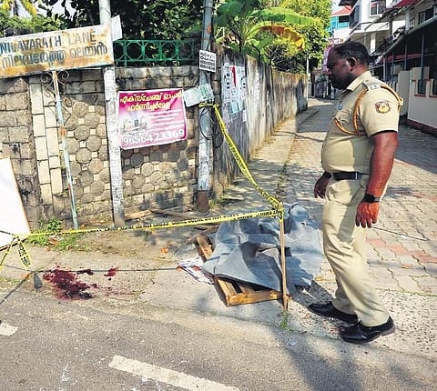 A police officer examining the spot where the woman was hacked by Farooq on Azad Road in Kaloor on Saturday. (Photo | T P Sooraj, EPS)