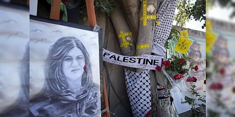 Yellow tape marks bullet holes on a tree and a portrait and flowers create a makeshift memorial, at the site where Palestinian-American Al-Jazeera journalist Shireen Abu Akleh was shot and killed. (Fi
