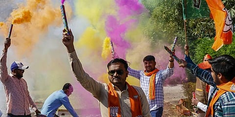 BJP workers burn firecrackers celebrating the party's decisive lead in Gujarat Assembly elections, in Gandhinagar. (Photo | PTI)