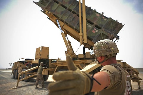 U.S. Army Spc. Scottlin Bartlett of the 5-52 Air Defense Artillery Battalion signals to a colleague while working near a Patriot missile battery at Al-Dhafra Air Base in Abu Dhabi. (Photo | AP)