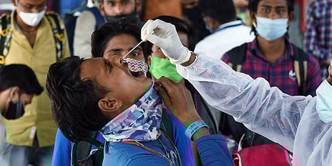 An health worker collects a nasal swab sample of a passenger for COVID-19 test at Dadar railway station in Mumbai. (Photo| ANI)