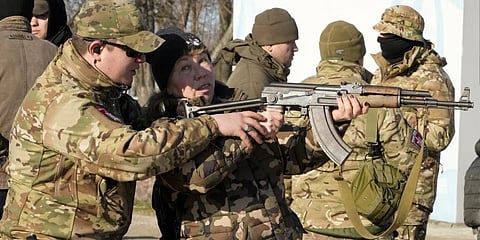 An instructor shows a woman how to use a Kalashnikov assault rifle, as members of a Ukrainian far-right group train, in Kyiv, Ukraine, Sunday, Feb. 13, 2022.(Photo | AP)