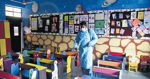 A worker sanitises a classroom ahead of the reopening of schools in the national capital on Monday, Feb 14, 2022. (Photo | EPS, Parveen Negi)