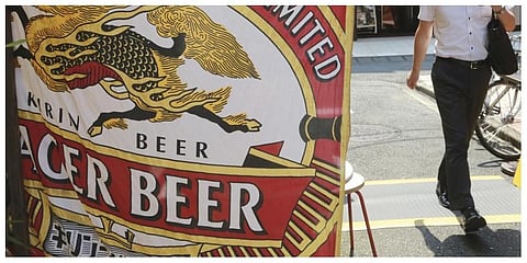 A man walks near an advertisement of a Kirin brand beer in Tokyo . (Photo: AP)