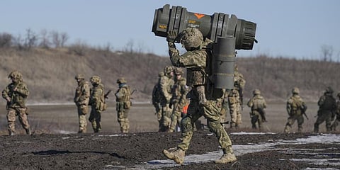 A Ukrainian serviceman carries an NLAW anti-tank weapon during an exercise in the Joint Forces Operation Feb. 15, 2022.(Photo | AP)