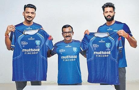 Kochi Blue Spikers head coach MH Kumara (centre) and players Deepesh Kumar Sinha (left) and captain Karthik A (right) exhibiting the team’s jersey