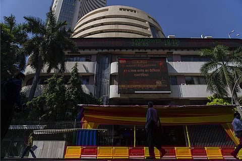 People watch the stock market index on a display screen on the facade of the Bombay Stock Exchange (BSE) building in Mumbai. (Photo | AP)