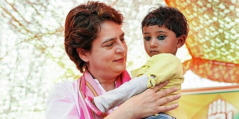 AICC General Secretary Priyanka Gandhi Vadra holds a child, during a corner meeting for Uttar Pradesh Assembly elections, in Raebareli. (Photo | PTI)