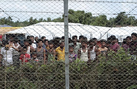 Rohingya refugees gather near a fence during a government organized media tour, to a no-man's land between Myanmar and Bangladesh, on June 29, 2018. (Photo | AP)