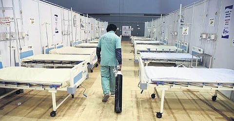 A health worker carries an oxygen cylinder in an empty hospital ward. (File photo)