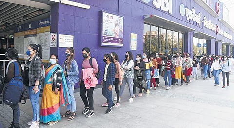 Commuters, mostly students, stand in a long queue outside Vishwavidyalaya Metro Station on Monday, Feb 21, 2022. (Photo | EPS, Parveen Negi)