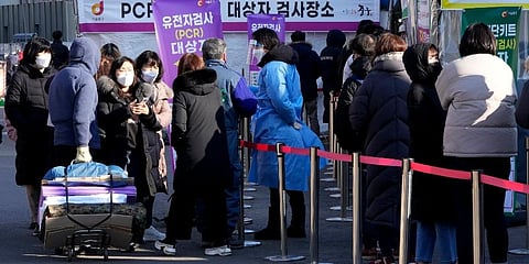 A medical worker, center, guides people as they wait for their coronavirus test at a makeshift testing site in Seoul, South Korea. (Photo |AP)