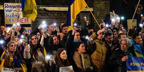 Demonstrators hold placards and flags as they attend a protest outside the Russian Embassy. (Photo | AP)