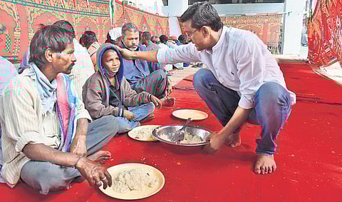 Hunger activist Syed Osman Azhar Maqsusi shares a light moment with a boy while serving him food near the Dabeerpura Railway bridge in Hyderabad. (Photo | EPS, S Senbagapandiyan)