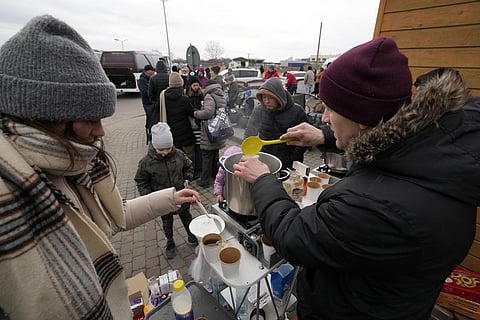 People fleeing the conflict from neighboring Ukraine, receive hot beverages at the border crossing in Medyka, southeastern Poland. (Photo | AP)
