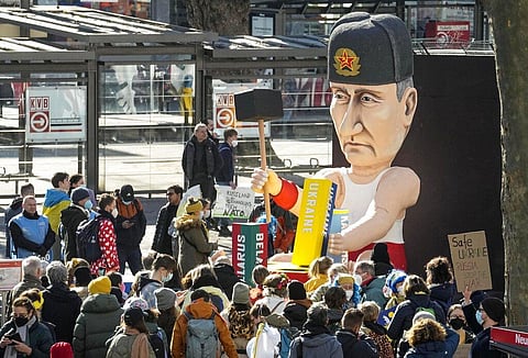 A satirical carnival float depicts Russia's President Vladimir Putin playing with the Ukraine to restore the Soviet Union on a square in Cologne, Germany. (Photo | AP)