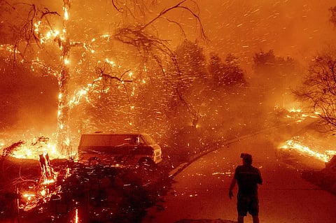 Bruce McDougal watches embers fly over his property as the Bond Fire burns through the Silverado community in Orange County, Calif., on Dec. 3, 2020. (AP Photo/Noah Berger, File)