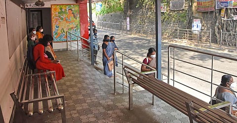 Commuters waiting at the bus shelter at Bakery Junction on Tuesday. (Photo | B P Deepu, EPS)
