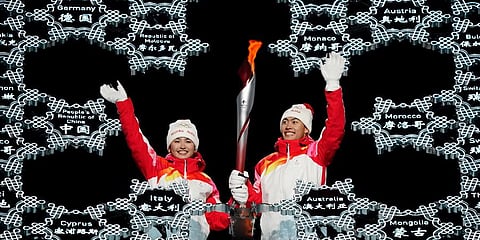 Olympic torch is brought into the stadium by Dinigeer Yilamujian and Zhao Jiawen during the opening ceremony of the 2022 Winter Olympics, Friday, Feb. 4, 2022, in Beijing. (Photo | AP)