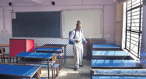 A worker sanitises a classroom at a Delhi government school in Mayur Vihar ahead of reopening on Monday. (Photo | Parveen Negi)