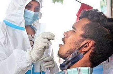 Health worker collects a swab sample from a man | Express