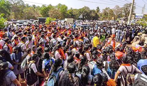 Students wearing saffron robes and hijab stage a protest outside the Mahatma Gandhi Memorial College campus, in Udupi district, Tuesday, Feb. 8, 2022. (Photo | PTI)