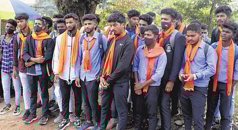 Students of a Madikeri college arrive on campus wearing saffron shawls on Monday