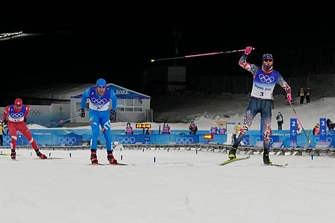 Johannes Hoesflot Klaebo, right, celebrates a gold medal finish ahead of silver medal finisher Federico Pellegrino, and bronze medal finisher Alexander Terentev. (Photo | AP)