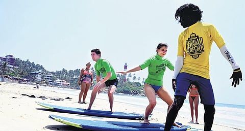 Surfboard specialist trains a Russian couple at Kovalam beach |Vincent Pulickal