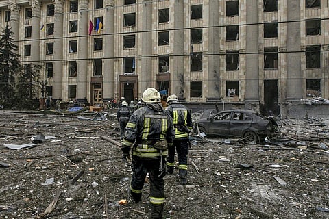 Ukrainian emergency service personnel work outside the damaged City Hall building following shelling, in Kharkiv, Ukraine. (Photo | AP)