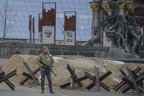 An armed man stands near a barricade during an air raid alarm in Maidan Square, in Kyiv, Ukraine, Tuesday, March 1, 2022. (Photo | AP)